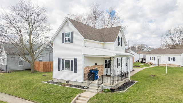 522 E High St, Saint Marys, OH 45885 - back of house featuring fence, a yard, a porch, and roof with shingles