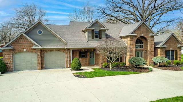 traditional home with brick siding, an attached garage, driveway, and roof with shingles