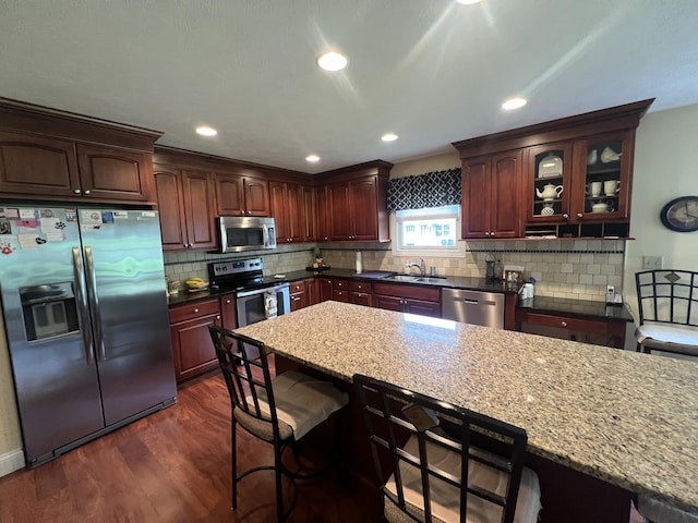 2732 Summer Field Trl, Sidney, OH 45365 - kitchen featuring appliances with stainless steel finishes, dark wood finished floors, a kitchen bar, decorative backsplash, and recessed lighting