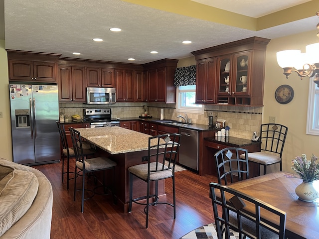 2732 Summer Field Trl, Sidney, OH 45365 - kitchen with stainless steel appliances, dark wood-style flooring, a chandelier, glass insert cabinets, and tasteful backsplash