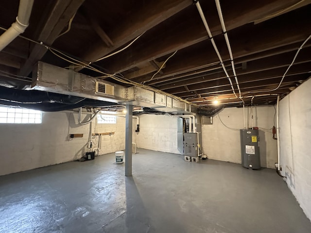 basement featuring heating unit and electric water heater