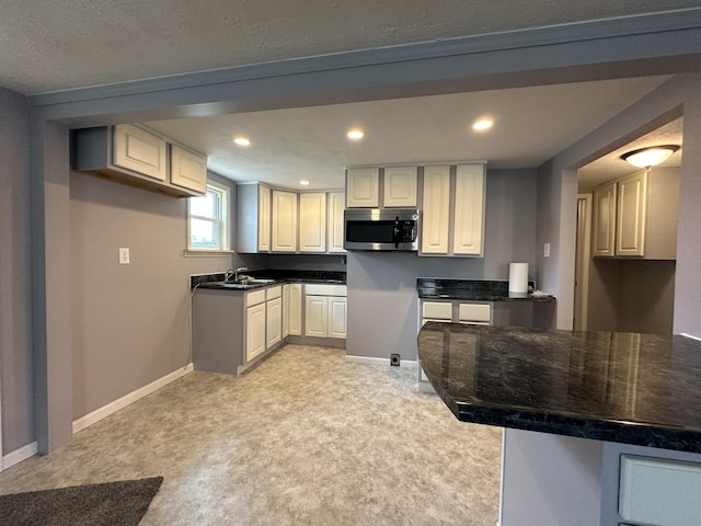 kitchen with light colored carpet and white cabinets