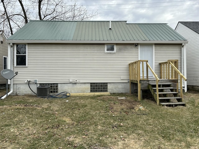 rear view of property with a lawn and central air condition unit