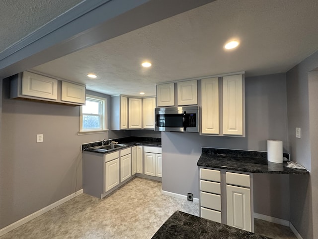 kitchen featuring white cabinetry, sink, and a textured ceiling