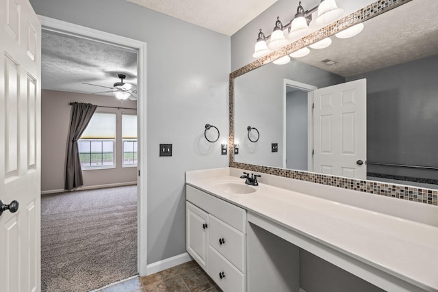 bathroom featuring a ceiling fan, a textured ceiling, baseboards, and vanity