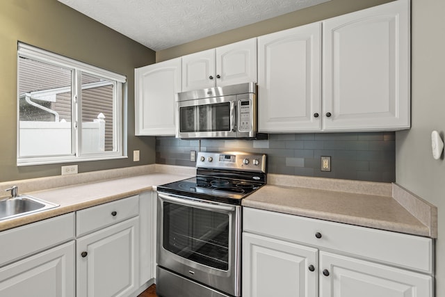 kitchen featuring tasteful backsplash, stainless steel appliances, and white cabinetry