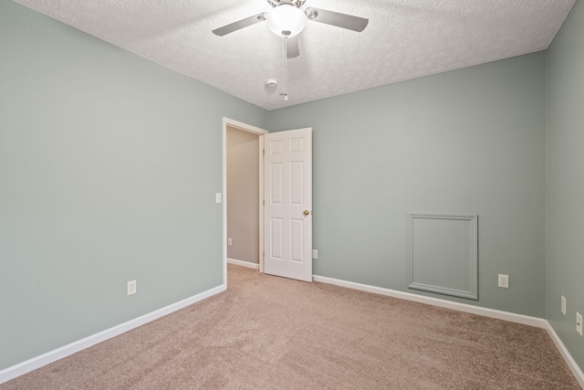 carpeted spare room with baseboards, ceiling fan, and a textured ceiling