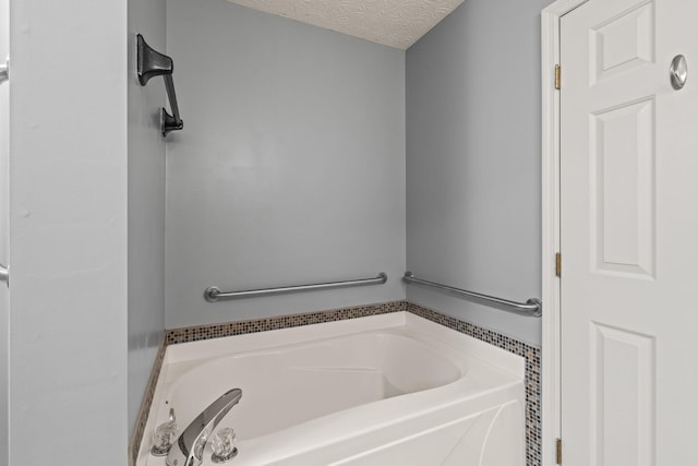 bathroom with a textured ceiling and a garden tub