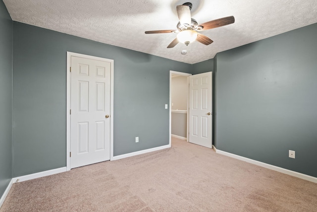 unfurnished bedroom with baseboards, a textured ceiling, and carpet floors