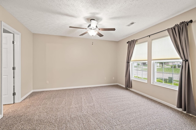 spare room featuring a ceiling fan, carpet flooring, and a textured ceiling