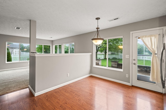 interior space featuring plenty of natural light, wood finished floors, and visible vents