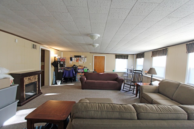 living room with carpet floors, visible vents, and a glass covered fireplace