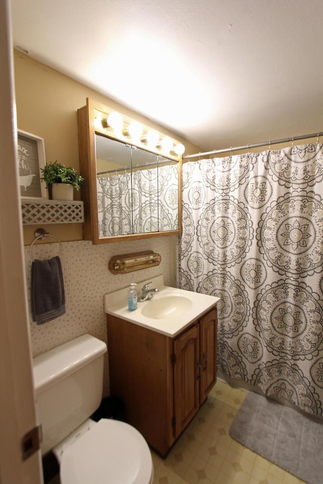 bathroom with curtained shower, vanity, toilet, and tile patterned floors