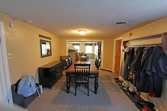 dining space featuring carpet floors, baseboards, visible vents, and a textured ceiling