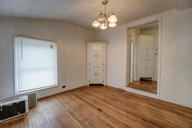 49 S W St, Versailles, OH 45380 - unfurnished dining area with hardwood / wood-style floors, lofted ceiling, a chandelier, and wooden walls