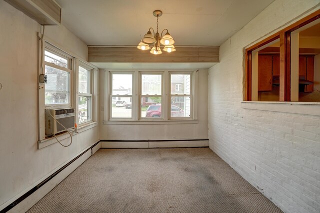 carpeted spare room with baseboard heating, an inviting chandelier, a wealth of natural light, and cooling unit