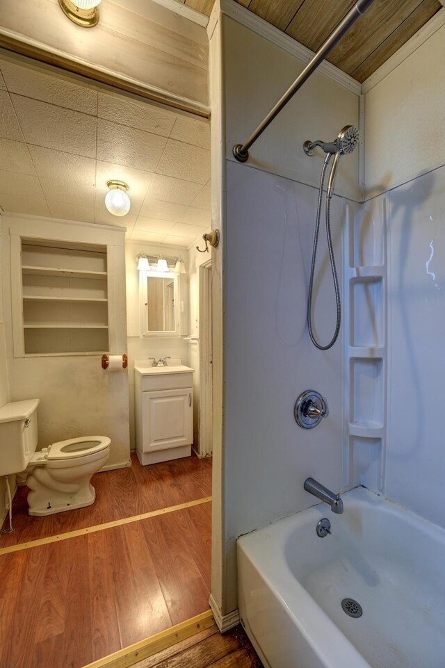 full bathroom featuring vanity, ornamental molding, wood finished floors, toilet, and washtub / shower combination