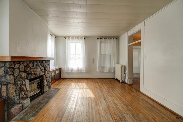 49 S W St, Versailles, OH 45380 - unfurnished living room with radiator, hardwood / wood-style floors, a fireplace, and baseboards