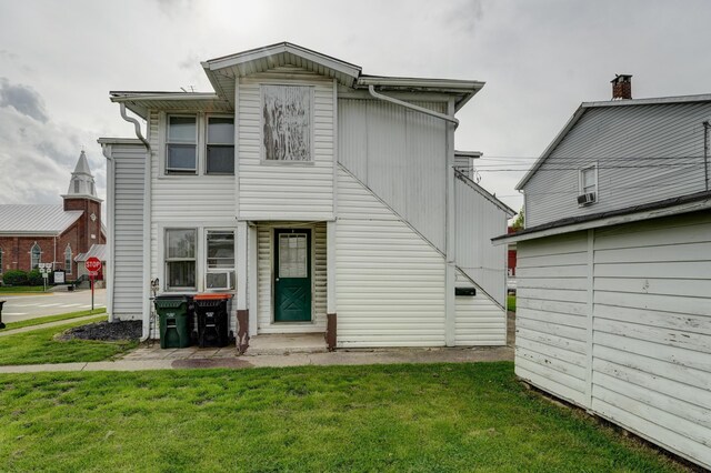 exterior space featuring cooling unit and a front yard