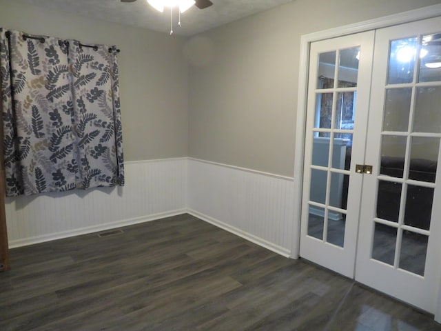spare room with wainscoting, ceiling fan, french doors, and dark wood-style floors