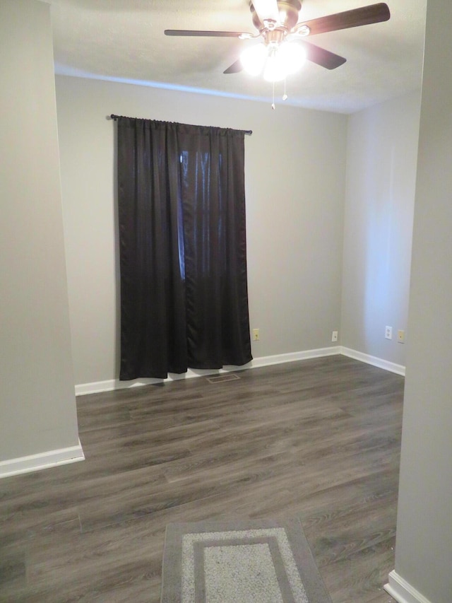 spare room featuring baseboards, ceiling fan, and wood finished floors