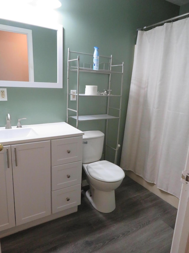 full bath with vanity, a shower with shower curtain, wood finished floors, and toilet