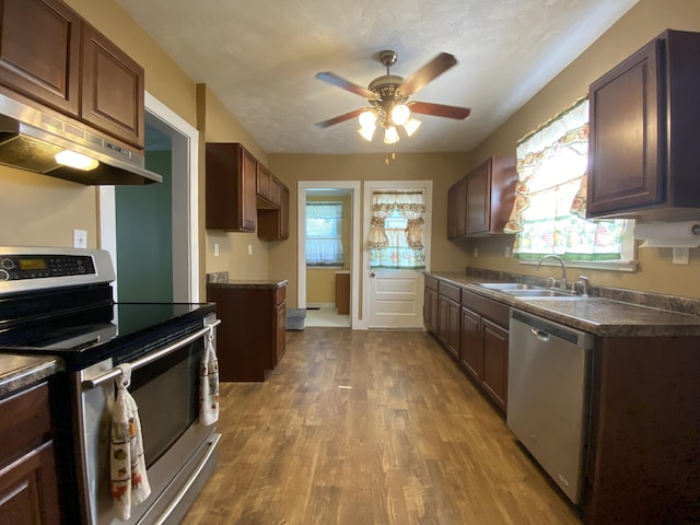 1208 Broadway St, Springfield, OH 45504 - kitchen with stainless steel appliances, ventilation hood, dark countertops, wood finished floors, and healthy amount of natural light