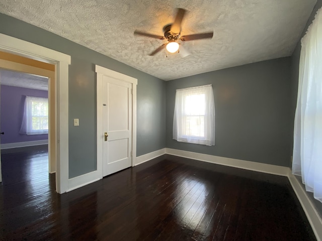 1208 Broadway St, Springfield, OH 45504 - unfurnished room featuring a textured ceiling, dark wood-style flooring, plenty of natural light, and a ceiling fan