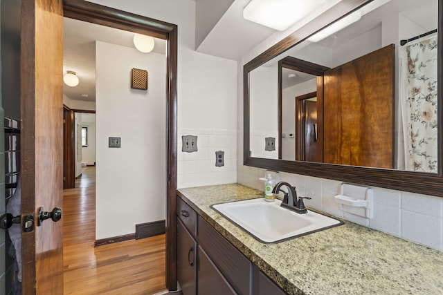 5899 N Springcreek Stringtown Rd, Piqua, OH 45356 - bathroom with wood finished floors, vanity, and backsplash