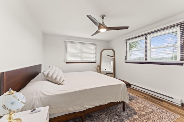 5899 N Springcreek Stringtown Rd, Piqua, OH 45356 - bedroom with baseboard heating, wood finished floors, and ceiling fan