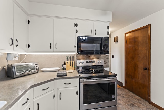 5899 N Springcreek Stringtown Rd, Piqua, OH 45356 - kitchen with black microwave, stainless steel electric range oven, white cabinetry, light countertops, and stone finish flooring