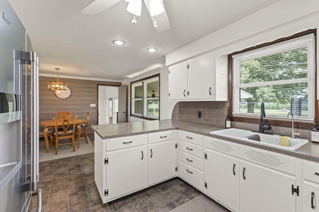 5899 N Springcreek Stringtown Rd, Piqua, OH 45356 - kitchen with a peninsula, stone finish floors, high end refrigerator, a chandelier, and recessed lighting
