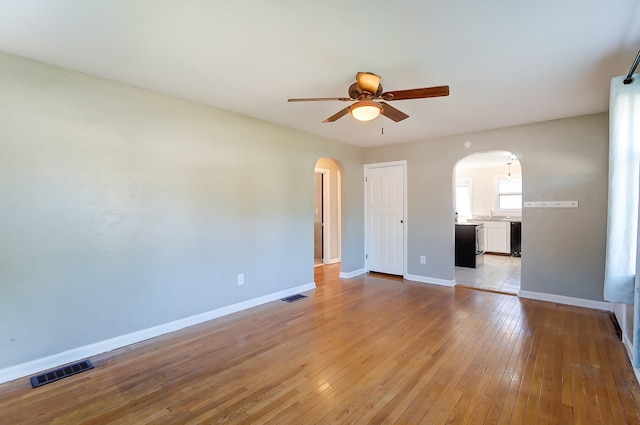 unfurnished bedroom with ceiling fan, connected bathroom, sink, and light hardwood / wood-style flooring