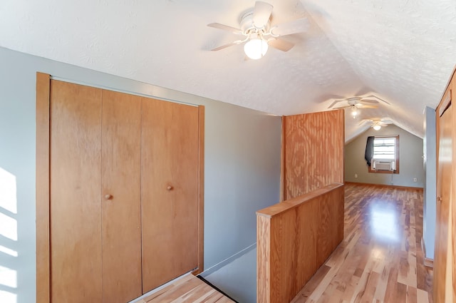 bonus room featuring ceiling fan, lofted ceiling, a textured ceiling, and light hardwood / wood-style floors