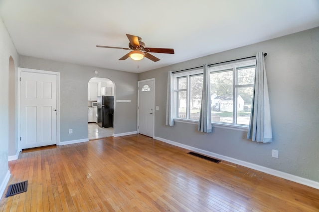 unfurnished living room with light hardwood / wood-style flooring and ceiling fan