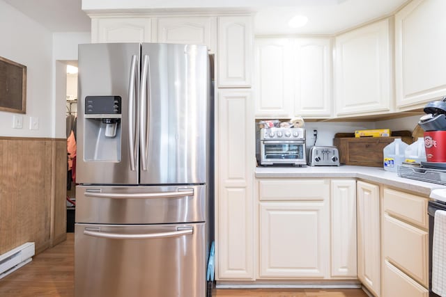 13730 Seminole Path, Lakeview, OH 43331 - kitchen with stainless steel refrigerator with ice dispenser, baseboard heating, light countertops, light wood-style flooring, and white cabinets