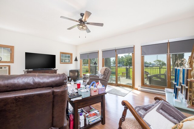 13730 Seminole Path, Lakeview, OH 43331 - living area featuring a baseboard heating unit, a ceiling fan, wood finished floors, and a wood stove