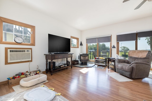 13730 Seminole Path, Lakeview, OH 43331 - living area featuring a wood stove, an AC wall unit, plenty of natural light, and ceiling fan