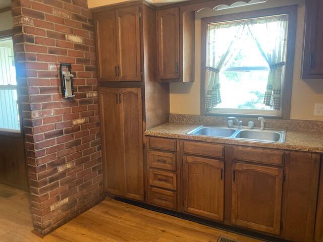 9770 Agerter Rd, Spencerville, OH 45887 - kitchen with healthy amount of natural light, light countertops, light wood-style floors, and brown cabinetry