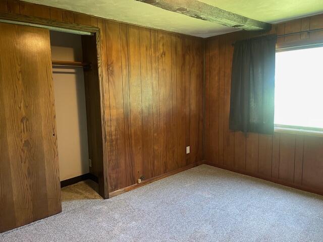 9770 Agerter Rd, Spencerville, OH 45887 - unfurnished bedroom featuring wood walls, carpet floors, and a closet