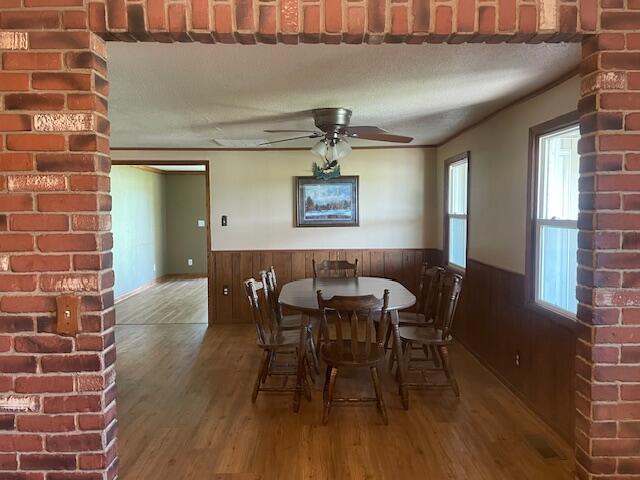 9770 Agerter Rd, Spencerville, OH 45887 - dining room featuring wainscoting, wood finished floors, ceiling fan, and wood walls