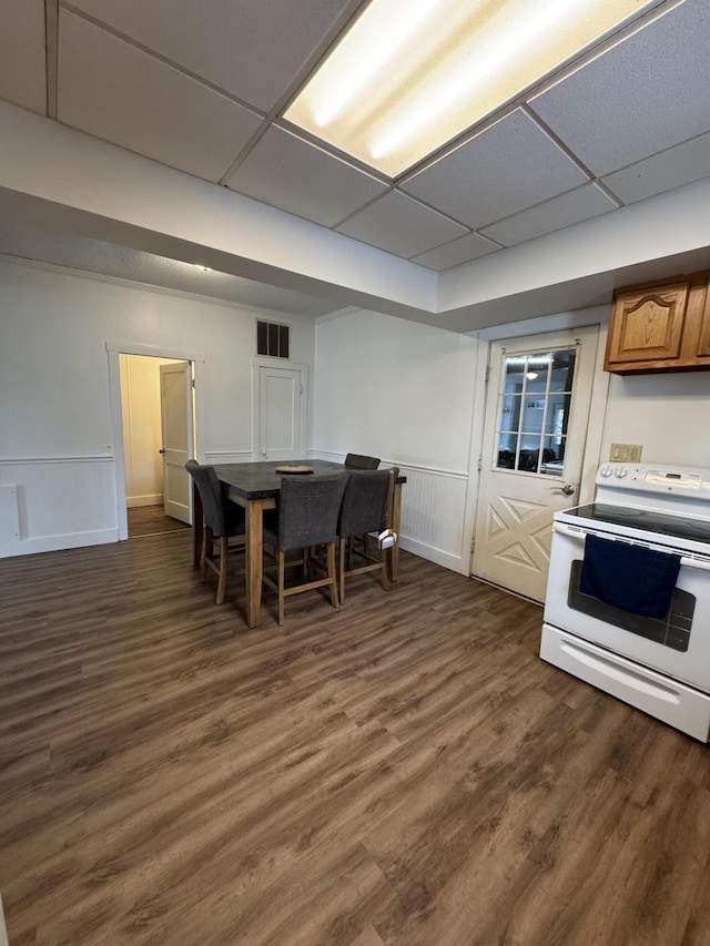 kitchen with electric range, visible vents, a drop ceiling, dark wood-style floors, and brown cabinets