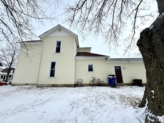 view of snow covered back of property