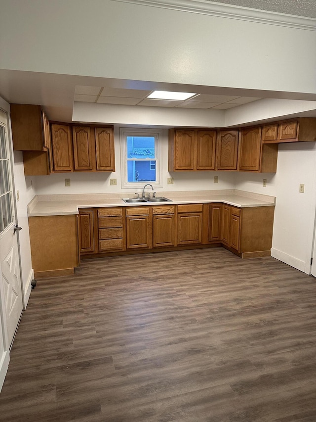 kitchen featuring light countertops, brown cabinetry, and a sink