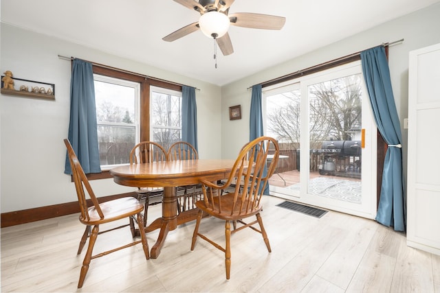 dining area with a ceiling fan, baseboards, light wood finished floors, and visible vents