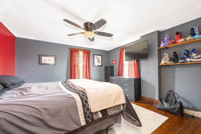 bedroom featuring baseboards, a ceiling fan, and wood-type flooring