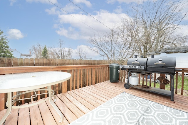 wooden terrace with a grill and fence