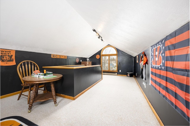 interior space with baseboards, carpet floors, lofted ceiling, and track lighting