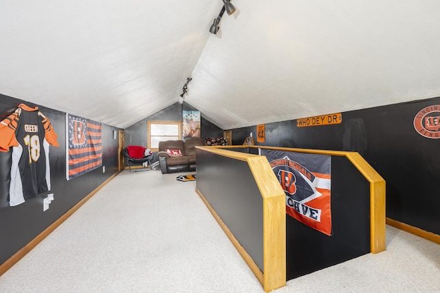 interior space featuring baseboards, vaulted ceiling, and carpet flooring