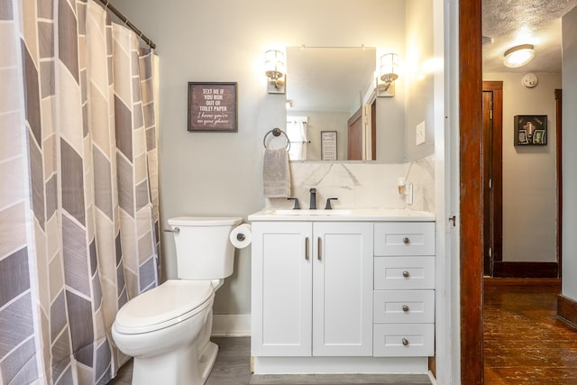 bathroom featuring decorative backsplash, baseboards, toilet, wood finished floors, and vanity